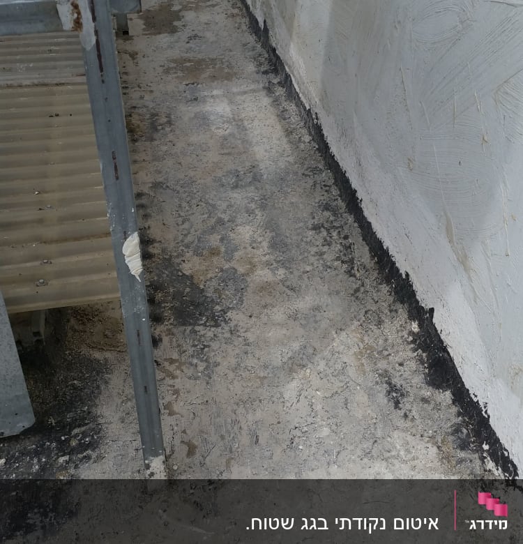 גג עם משטח בטון וקיר צבוע בלבן